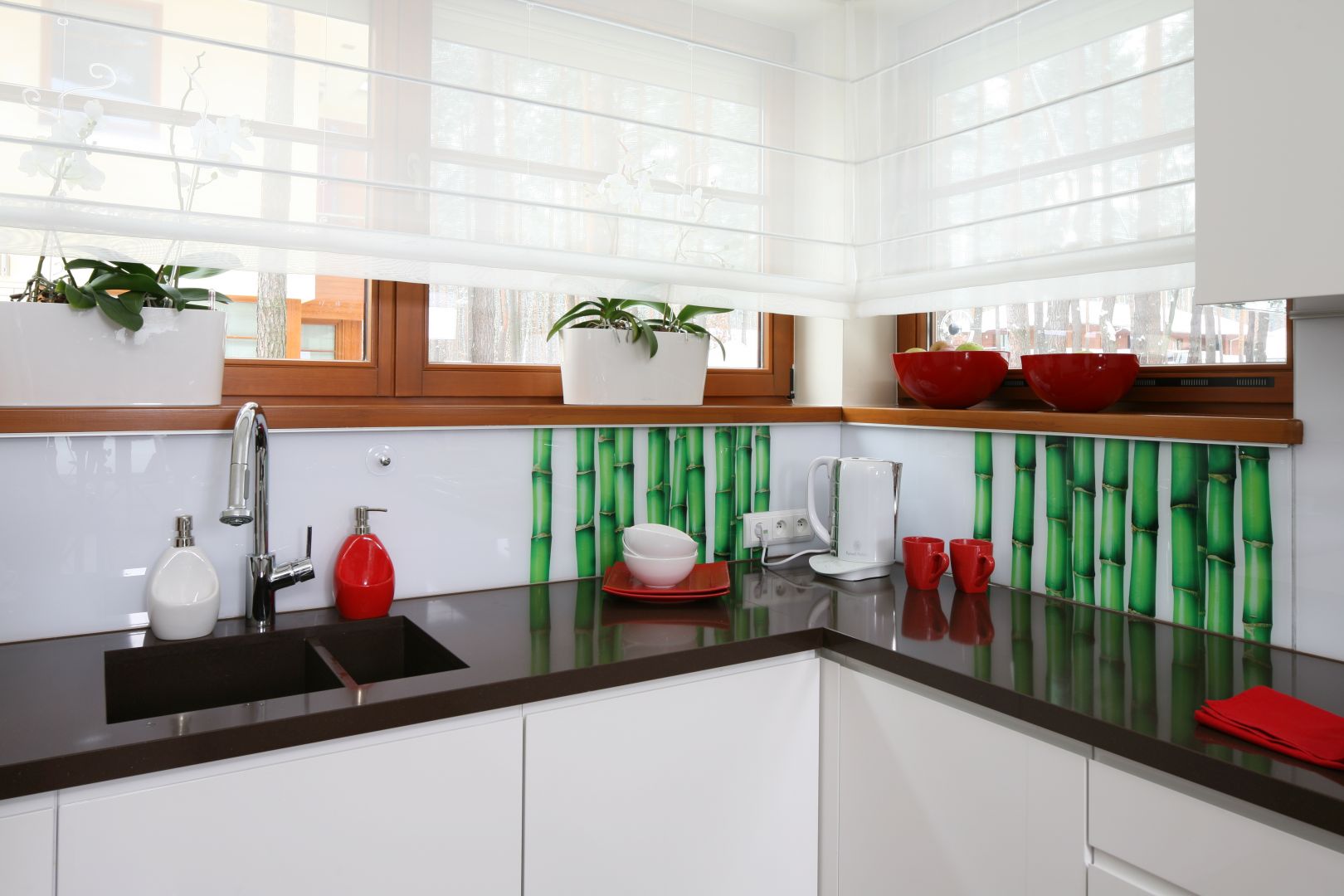 W białej kuchni mocny akcent kolorystyczny stanowi fototapeta z zielonymi bambusami. Wyłożono nią jedynie róg pod oknami. Projekt Katarzyna Mikulska -Sękalska. Fot. Bartosz Jarosz.