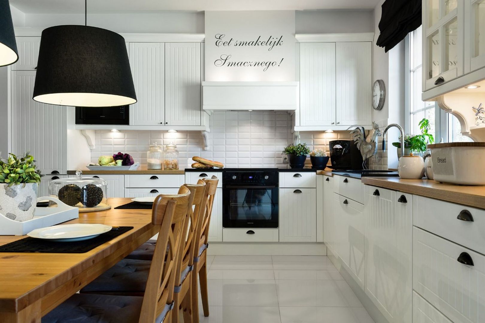Projekt kuchni w matowym odcieniu bieli, którego elementy zdobne - pionowe frezowania oraz uchwyty stylistycznie nawiązują do tradycyjnych wnętrz w stylu skandynawskim. Fot. Pracownia Mebli Vigo.