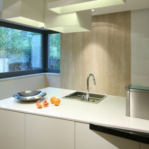 Reprezentacyjna część kuchni urządzona jest
w stylu minimalistycznym. Dominującą kompozycję bieli i czerni ociepla podłoga z dębowych desek. 