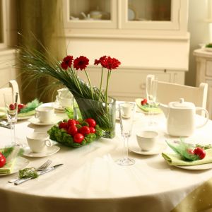 Minimalistyczna aranżacja stołu na Wielkanoc. Biały obrus i nowoczesna biała porcelana o geometrycznych formach zostały przełamane obecnością zieleni i czerwieni, które pięknie i elegancko ożywiają cały stół. Fot. Villa Italia.