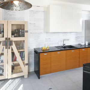 Szafki wiszące to nie jedyny jasny element wyposażenia kuchni. Designerska witryna z drewna 
dębowego,  projektu  Marty  Kruk,  pełni  funkcję przechowywania,  jak  również  podkreśla  loftowy 
charakter aranżacji.