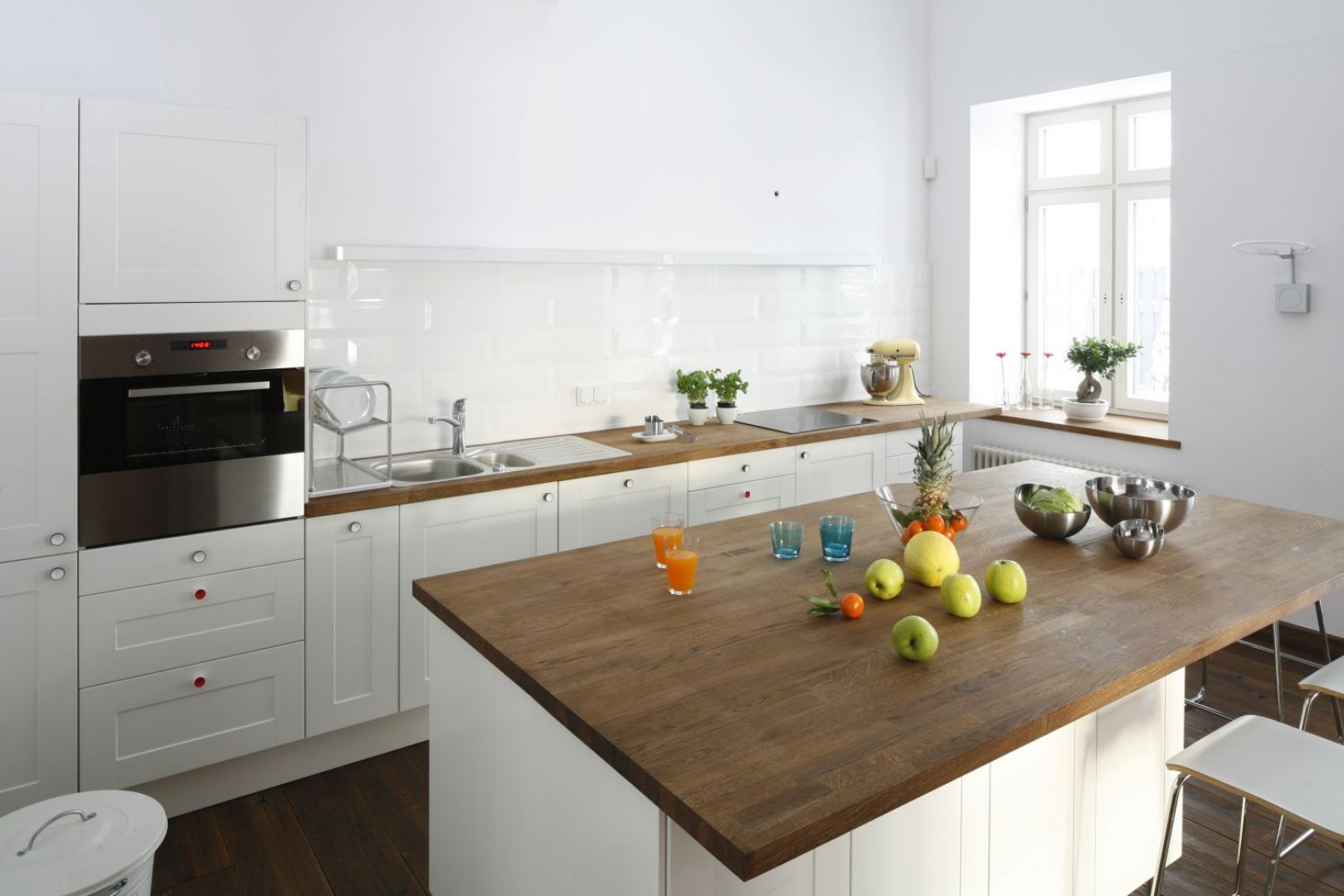 Skąpana w czystej bieli aranżacja kuchni stanowi ciekawy kontrast dla ceglanych ścian obecnych w całym domu. Projekt Konrad Grodziński. Fot. Bartosz Jarosz.