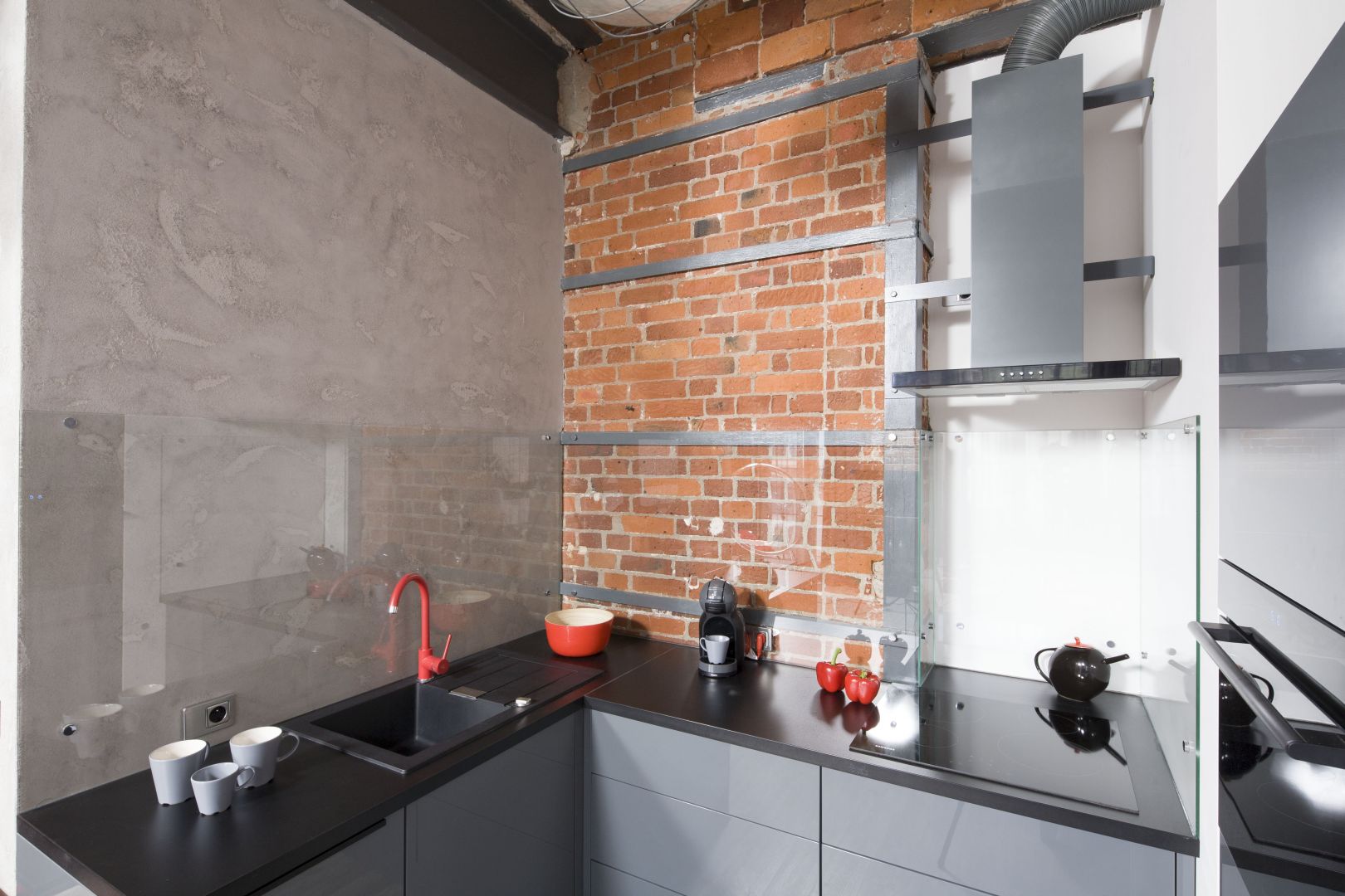 W kuchni surowy beton doskonale łączy się z ciepła cegłą. Projekt Nowa Papiernia. Fot. Bartosz Jarosz.
