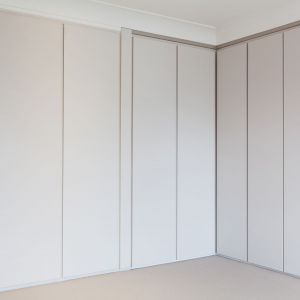 Praktyczne szafy są niemal niezauważalne i nie burzą minimalistycznej aranżacji wnętrza. Fot. Nick Leith-Smith
