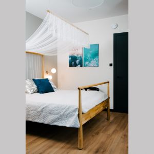 Sypialnia urządzona jest w spokojnej, jasnej kolorystyce, dzięki czemu zapewnia komfortowy sen i odpoczynek. Projekt: Barbara Bulska, Piotr Czajkowski, pracownia PLAN A. Fot. Adam Biernat