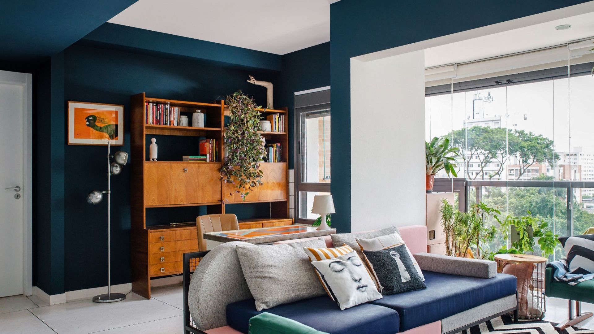 Sofa zaprojektowana na zamówienie przez architektów. W podobnym stylu Sona od Noti od 2.140 zł. Regał w stylu vintage, dywan Zarif Tapetes. Dom FM, projekt: Mombá Architektura (Argentyna). Zdjęcia: Felipe Lopez