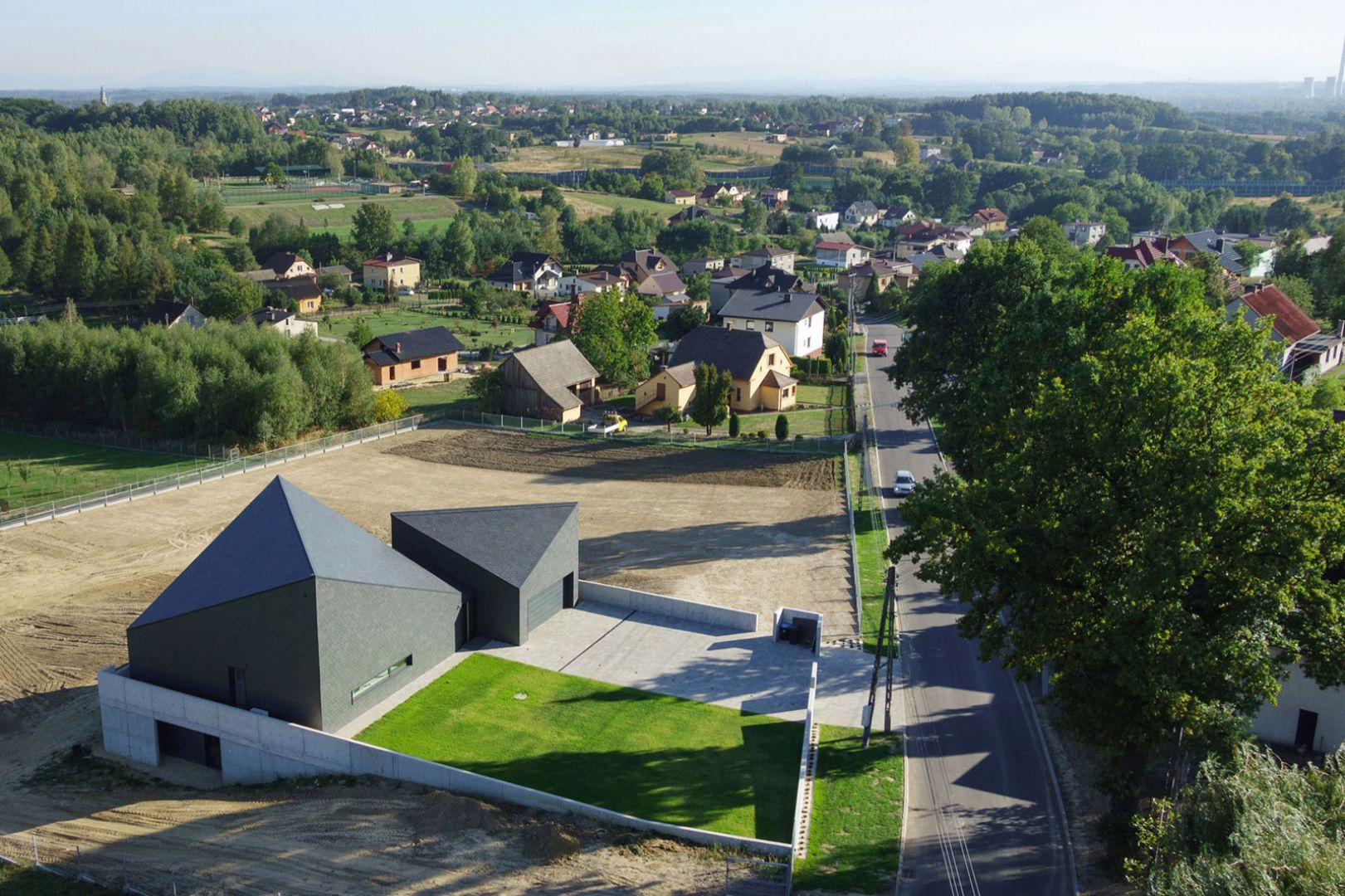 Nowoczesna bryła świetnie wpisuje się w pobliski krajobraz. Dom w Krostoszowicach. Autor: arch. Robert Skitek, arch. Jakub Zygmunt, RS+. Zdjęcia: Tomasz Zakrzewski, archifolio.pl