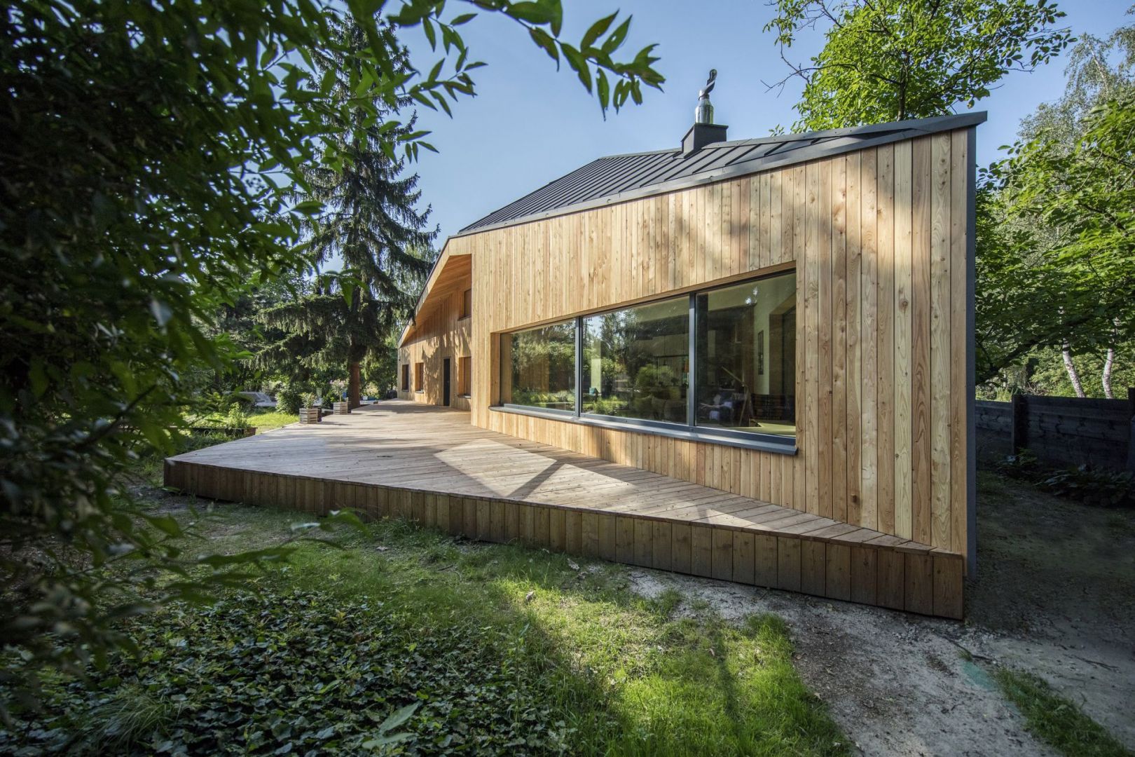Czteropłaszczyznowy, niesymetryczny dach o różnych kątach nachylenia połaci pokryty został grafitową blachą. Autorzy projektu: arch. Magdalena Beczak, arch. Maciej Beczak, Beczak/Beczak Architekci. Zdjęcia: Jan Karol Gołębiewski - jankarol.com