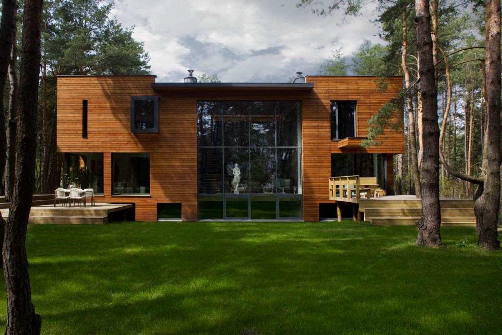 Dom został wybudowany na malowniczej działce pod Warszawą. Elewacja pokryta jest modrzewiowymi deskami oraz bazaltem powulkanicznym. Projekt i zdjęcia: Kulczynski Architekt