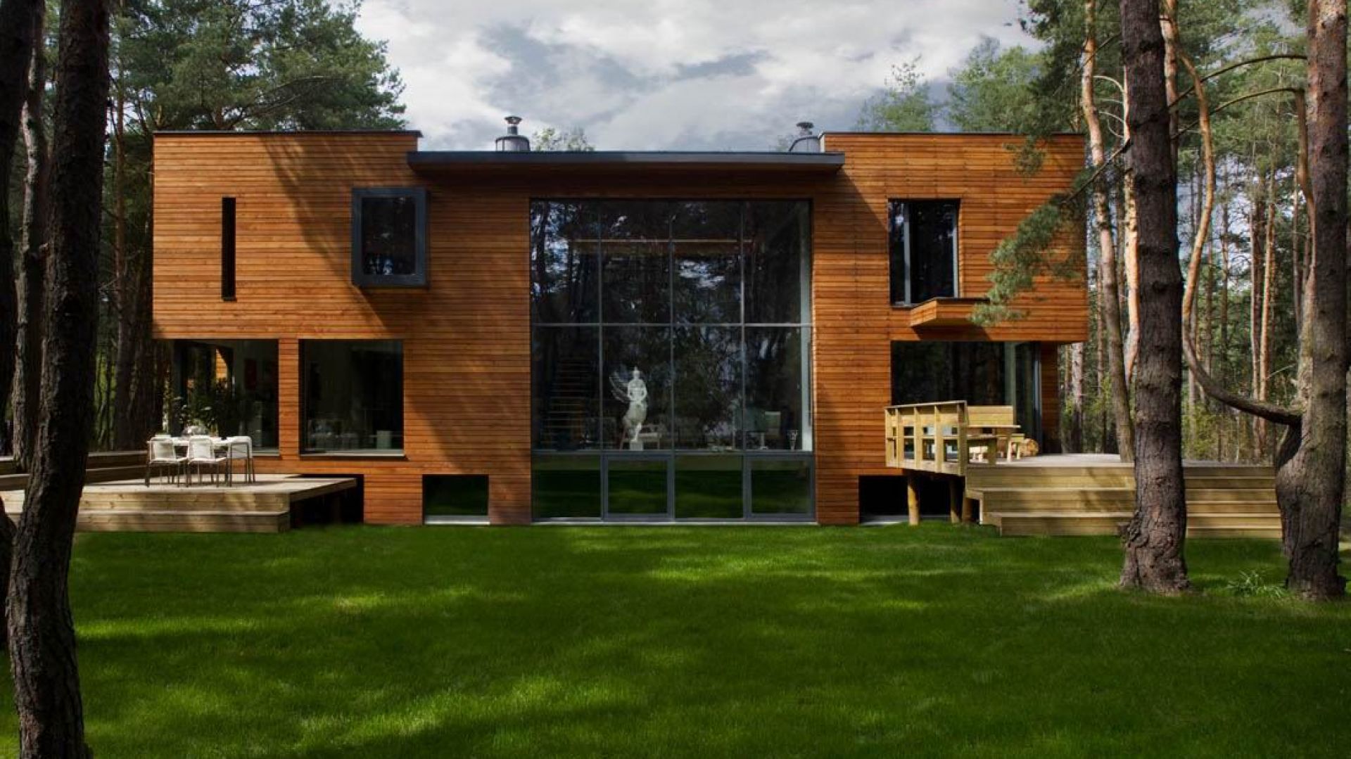 Dom został wybudowany na malowniczej działce pod Warszawą. Elewacja pokryta jest modrzewiowymi deskami oraz bazaltem powulkanicznym. Projekt i zdjęcia: Kulczynski Architekt