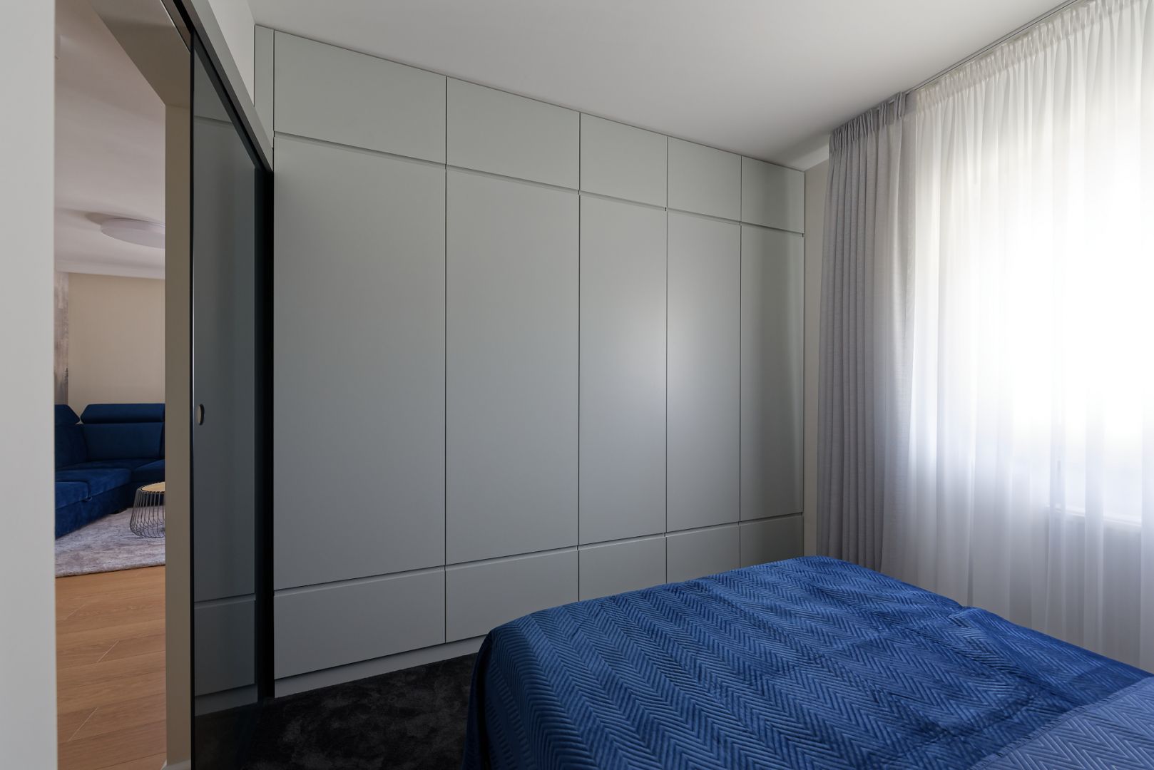 W sypialni znajduje się duża, pojemna szafa zapewniająca dużo miejsca na przechowywanie. Projekt: pracownia M-Studio. Fot. Radek Słowik