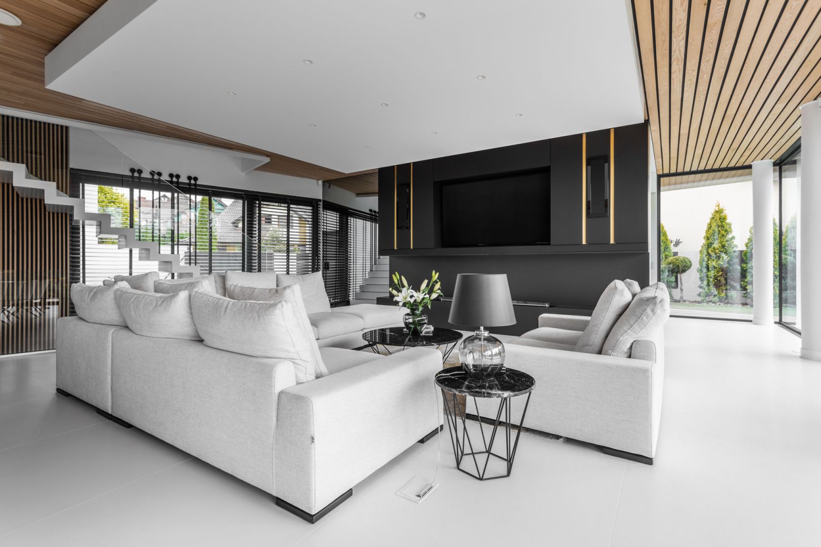 W salonie dominują neutralne barwy - czerń i biel, które ociepla drewno oraz złote dekory. Projekt Joanna Ochota Archimental Concept JOana. foto Mateusz Kowalik