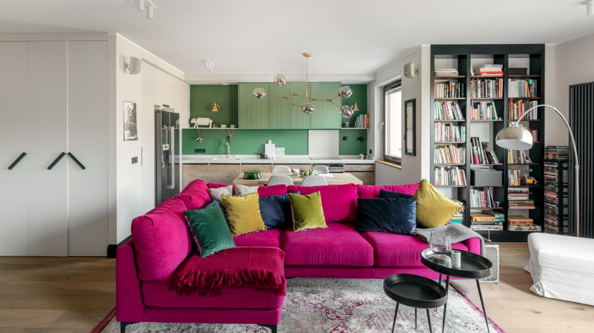 Mocnym punktem salonu jest narożnik w nasyconej barwie amarantu, zestawionej z nieco tylko mniej wyrazistym z odcieniem granatu i ochry. Projekt: Finchstudio. Fot. Aleksandra Dermont Ayuko Studio