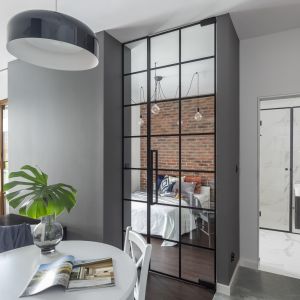 Głównym zabiegiem, który pozwolił architektom Decoroom otworzyć przestrzeń było zastąpienie ściany dzielącej sypialnię i salon szerokimi, sięgającymi sufitu przeszklonymi drzwiami. 