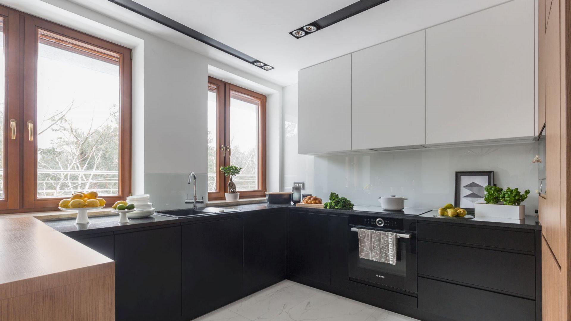 Białe szkło nad kuchennym blatem to najlepsze rozwiązanie do minimalistycznej, czarno-białej kuchni. Projekt Decoroom. Zdjęcia i stylizacja Marta Behling Pion Poziom Fotografia Wnętrz