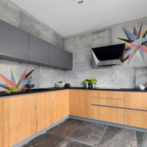Szare płytki doskonale imitują beton dodając kuchni surowego charakteru. Projekt Magdalena Lehmann.