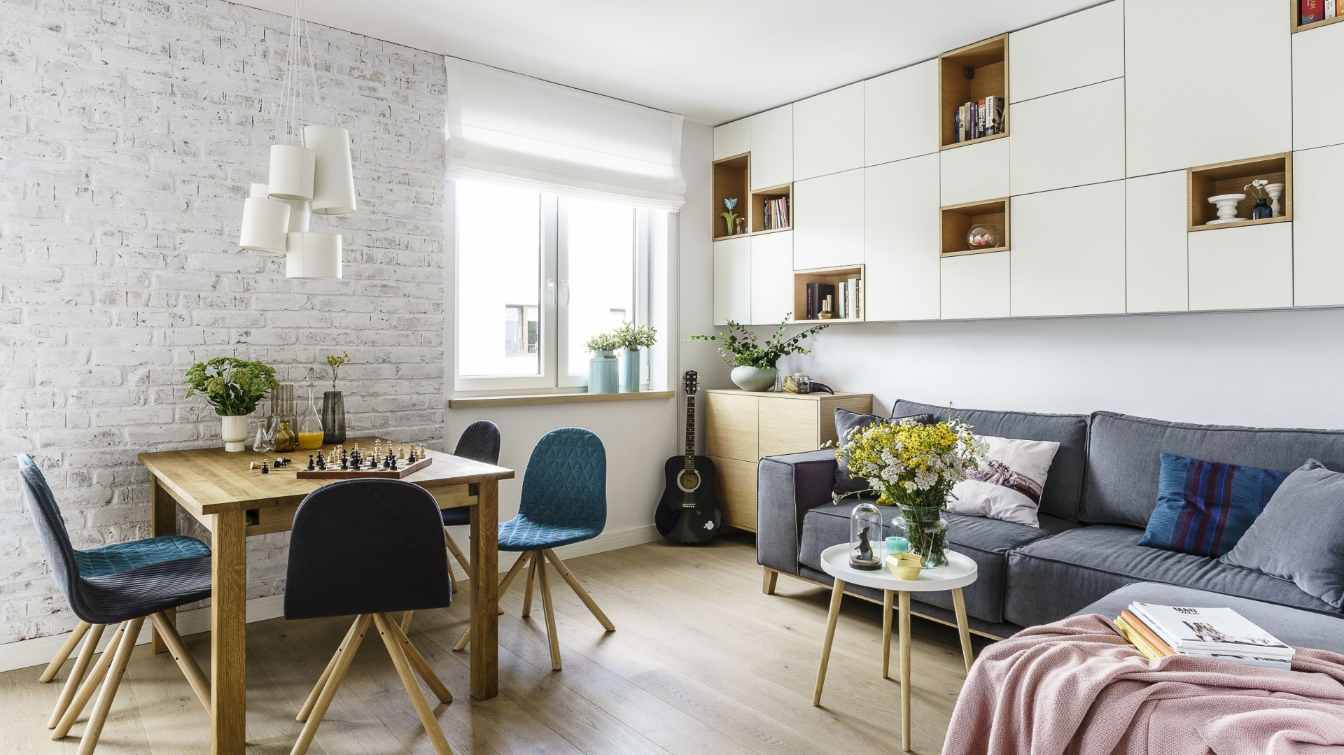Salon z jadalnią, ulokowaną zazwyczaj w pobliżu otwartej kuchni, sprawdzi się zarówno w obszernych, jak i niedużych mieszkaniach. Projekt Saje Architekci. Fot. Fotomohito