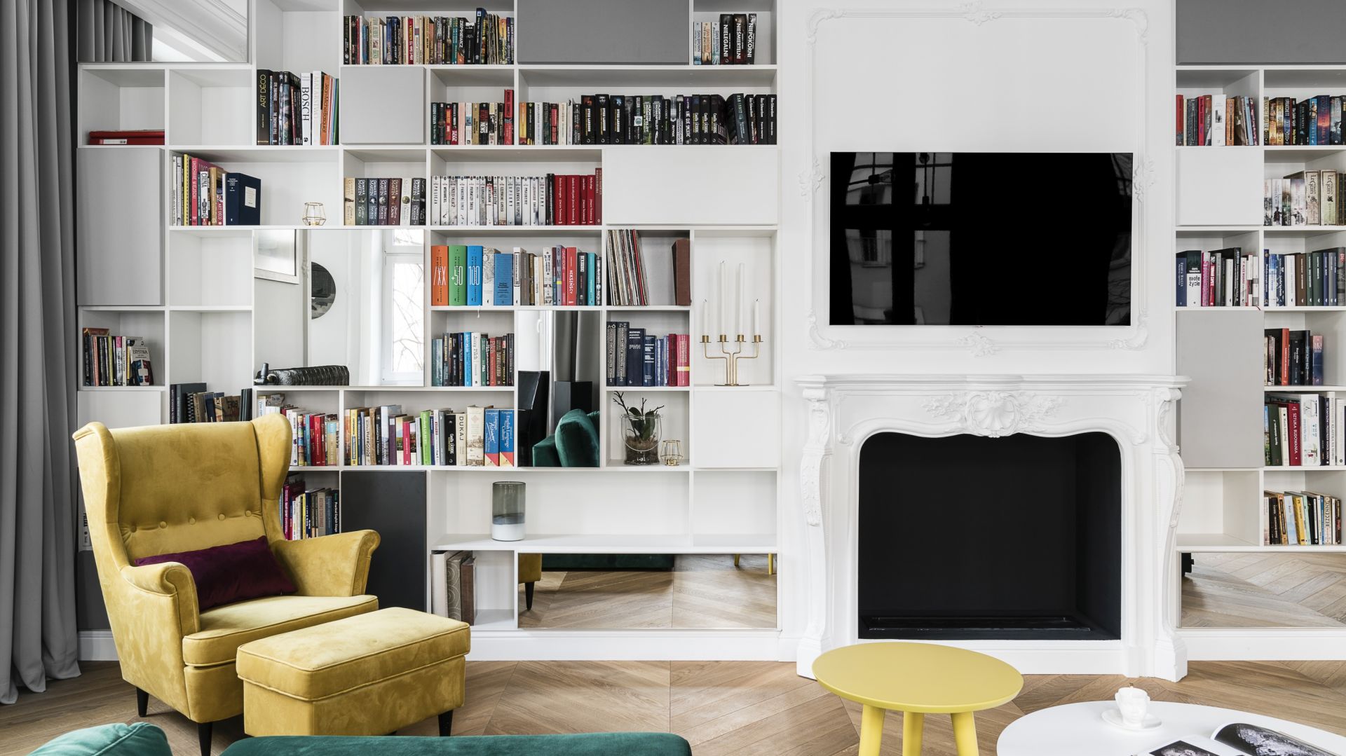 Regały na ścianie z kominkiem budują klimat domowej biblioteki. Projekt Anna Maria Sokołowska. Fot. Fotomohito