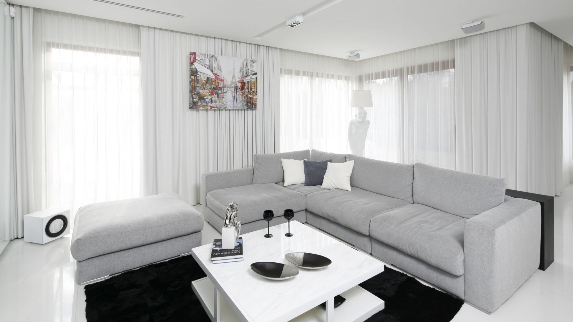 Salon urządzono w bielach i szarościach, które ożywiają dodatki w czarnych kolorach. Projekt: Małgorzata Muc, Joanna Scott. Fot. Bartosz Jarosz