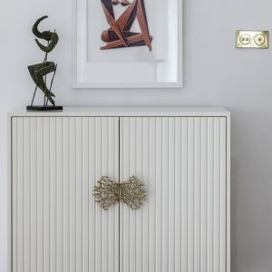 Komoda na mosiężnym stelażu z uchwytami Coral wytwarzanymi tradycyjną technologią odlewniczą (PAP DECO); sztuka Adama Bakalarza (Galeria Totuart). Sesja zdjęciowa promująca akcję #wspieramypolskidesign. Zdjęcia: Yassen Hristov. Stylizacja: Kamila Jakubowska-Szmyd 
