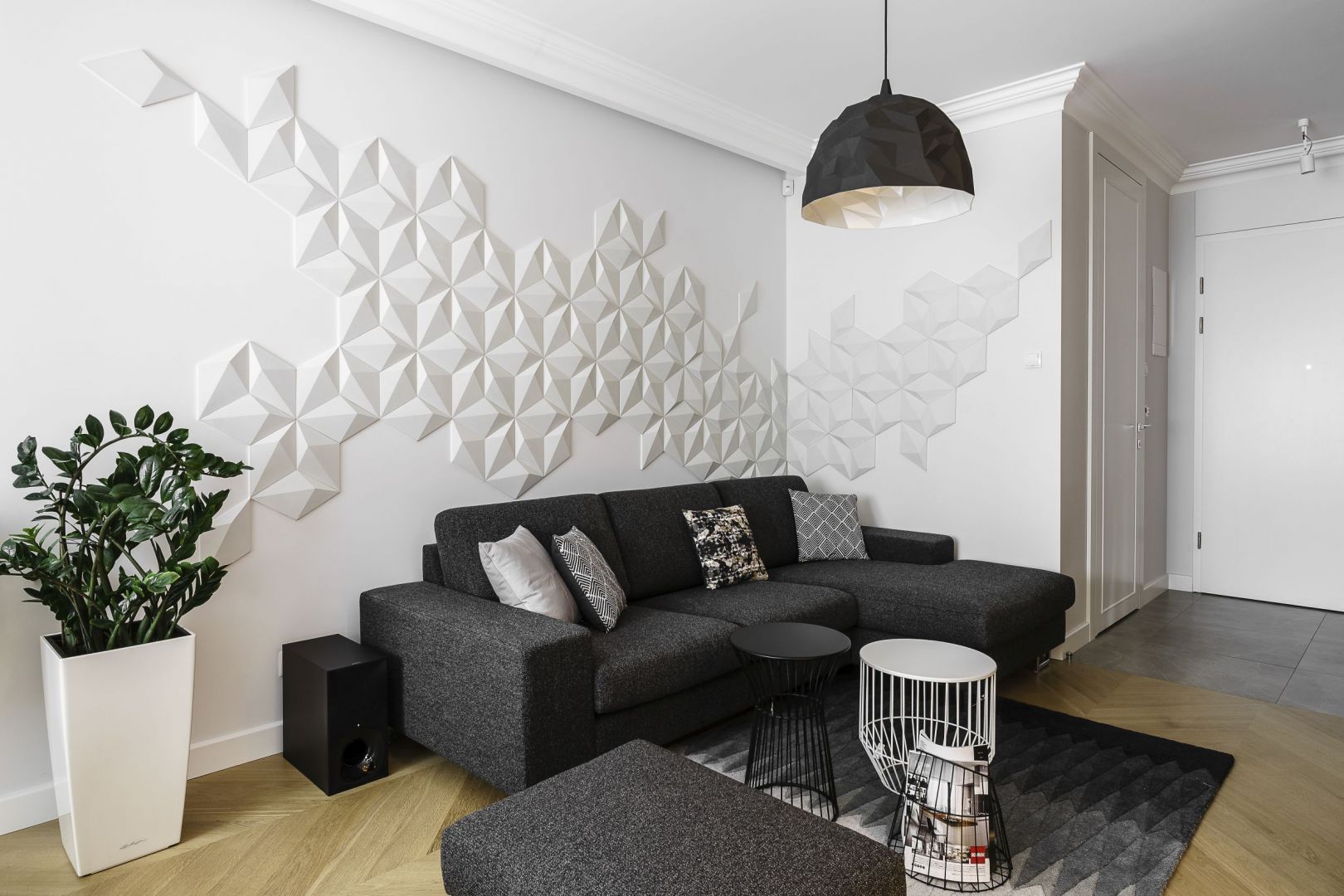 Białą ścianę za kanapą zdobią prefabrykowane płytki z betonu architektonicznego 3D. Tworzą bardzo ciekawą kompozycję na ścianie. Projekt: Anna Maria Sokołowska. Fot. Fotomohito