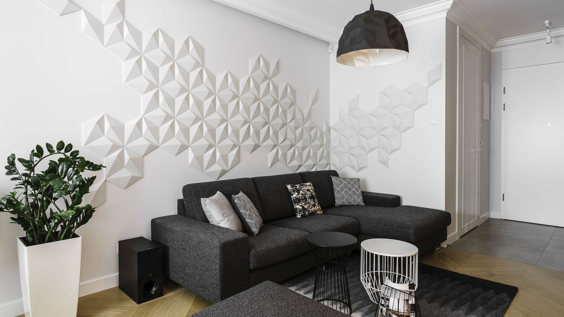 Białą ścianę za kanapą zdobią prefabrykowane płytki z betonu architektonicznego 3D. Tworzą bardzo ciekawą kompozycję na ścianie. Projekt: Anna Maria Sokołowska. Fot. Fotomohito