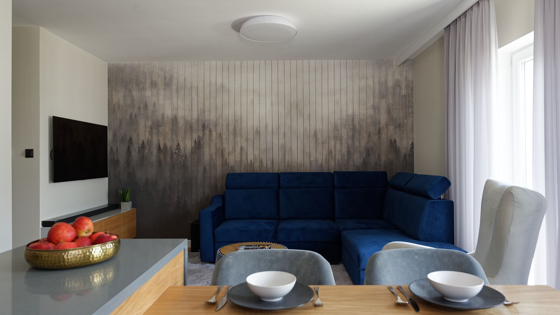 W tym niewielkim salonie za narożną kanapą znalazła się bardzo ciekawa tapeta. Projekt: pracownia M-Studio. Fot. Radek Słowik