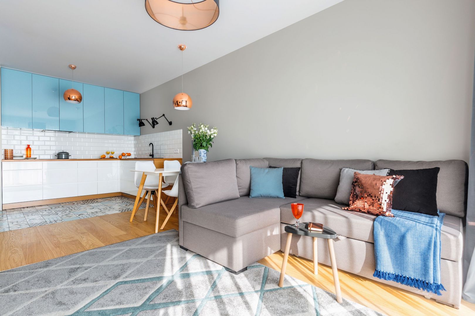 Kolorowe fronty szafek stanowią barwne tło dla strefy wypoczynku. Projekt Decoroom. Fot. Pion Poziom