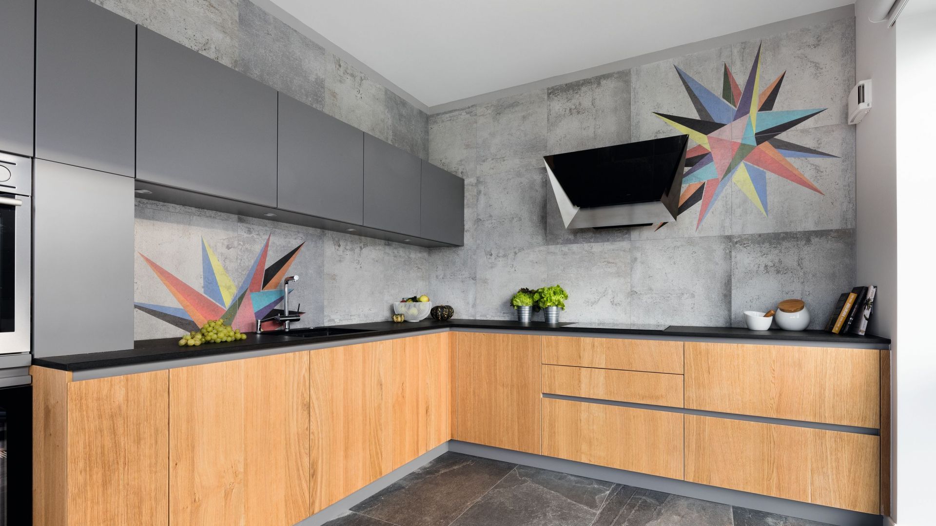 Zestawienie koloru szarego z drewnem świetnie sprawdził się w nowoczesnej kuchni. Jest elegancko i przytulnie. Projekt: Magdalena Lehmann. Fot. Bartosz Jarosz