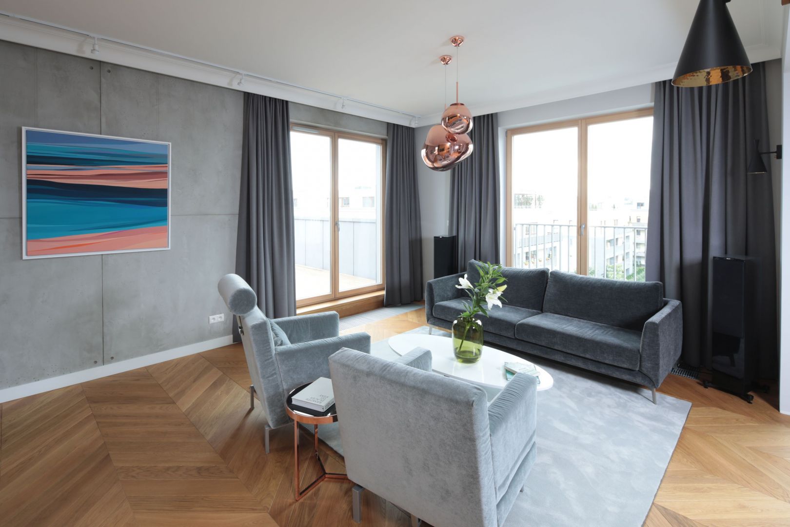 Nowoczesny salon pięknie zdobią lampy wiszące o prostej formie w kolorze miedzi. Jest tu też bardziej praktyczne oświetlenie. Projekt: Katarzyna Mikulska-Sękalska. Fot. Bartosz Jarosz