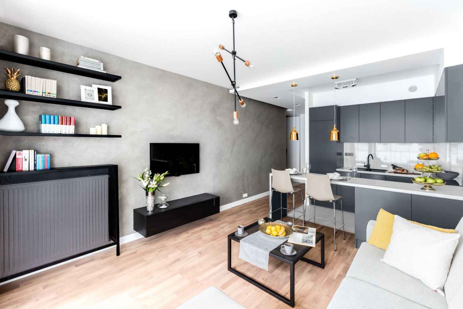 Na ścianie wykończonej betonowym tynkiem świetnie wygląda czarna, podwieszana szafka pod telewizor. Projekt i zdjęcia: Decoroom