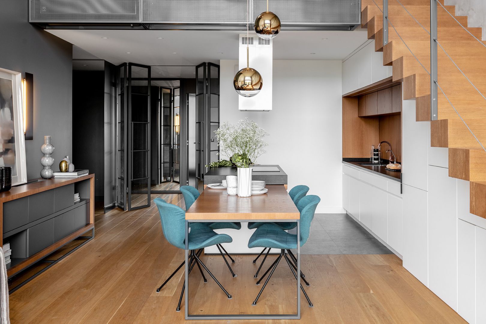 Dwie lampy wiszące o prostej, ładnej formie doskonale pasują do nowoczesnej, otwartej strefy dziennej. Projekt: JMW Architekci. Fot. Ola Dermont i JMW Architekci