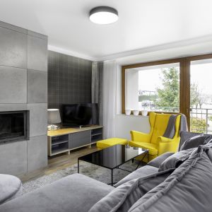 Szary salon rozświetla żółty fotel.Projekt Katarzyna Maciejewska. Fot. Dekorialove