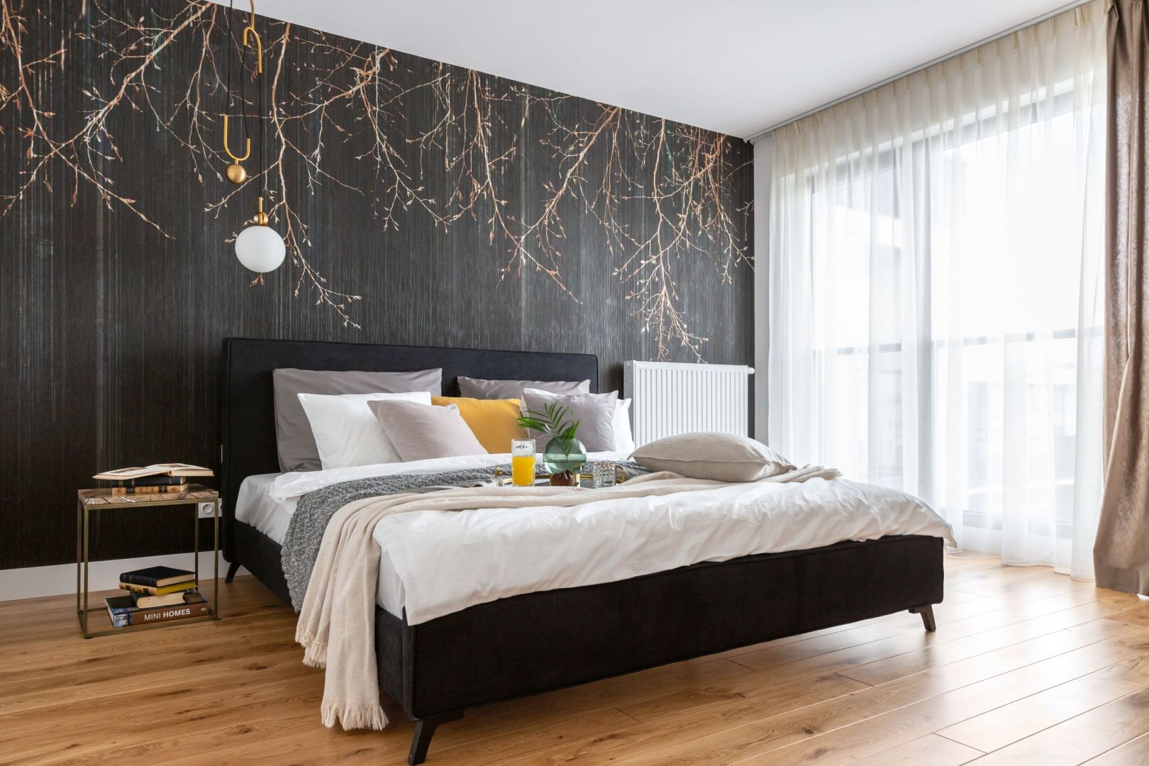 Ścianę za łóżkiem zdobi oryginalna tapeta. Projekt Decoroom. Fot. Pion Poziom