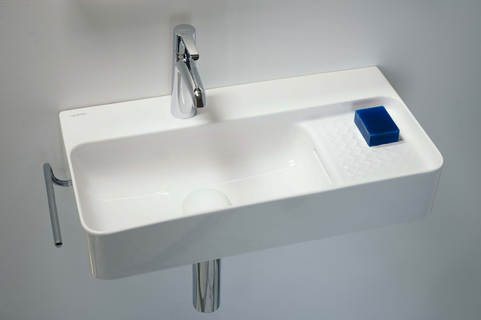 Umywalka z serii VAL zaprojektowana przez Konstantina Grcica to idealny wybór do małej łazienki. Na zdjęciu umywalka cienkościenna na bazie prostokąta o zaoblonych kątach, która wyposażona została w praktyczną półkę. Fot. Laufen