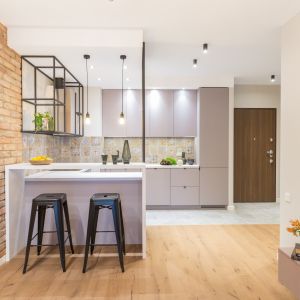 Szary kolor zabudowy kuchennej dobrze komponuje się z cegłą. Projekt Decoroom. Fot. Pion Poziom