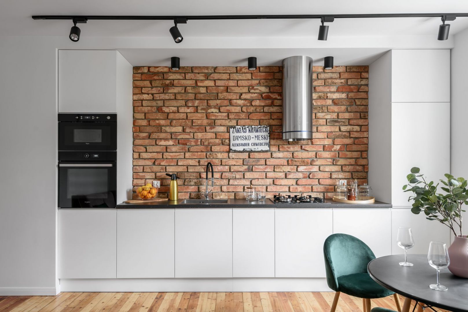 Częścią salonu jest też jednorzędowy aneks kuchenny w białym kolorze. Projekt: Magdalena i Robert Scheitza, pracownia SHLTR Architekci