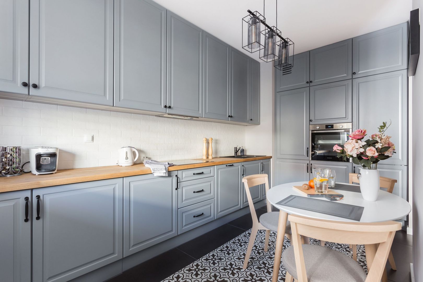 Серый кухонный гарнитур с деревянной столешницей в интерьере фото