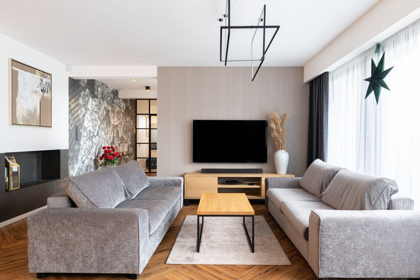 Ściana za telewizorem wykończona jest jasną, subtelną tapetą. Projekt: Aleksandra Michalak x Dekorian Home. Fot. Łukasz Michalak