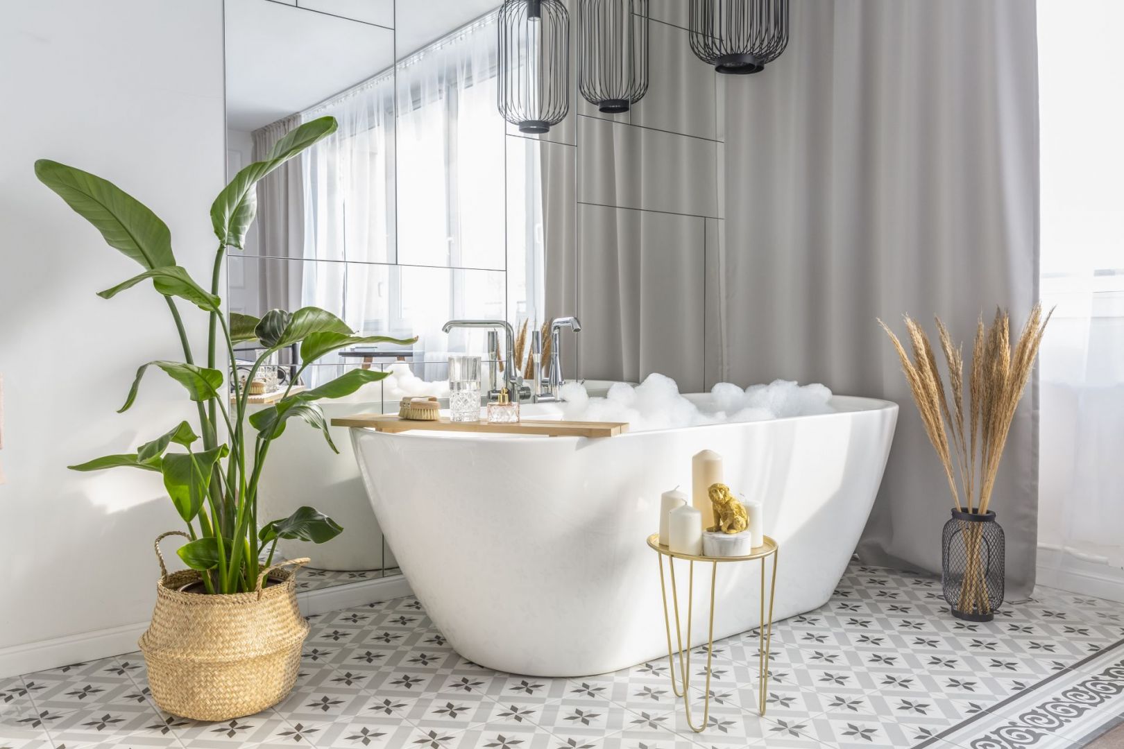 Duża wolnostojąca wanna Riho Inspire została umieszczona naprzeciwko szerokiego łóżka z dekoracyjną ramą. Projekt: Decoroom. Fot. Pion Poziom