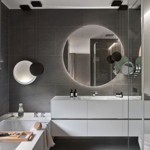 Okrągłe lustro w nowoczesnej łazience urządzone w szarej kolorystce. Projekt: Katarzyna Kraszewska Architektura Wnętrz. Fot. Tom Kurek