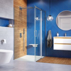 Przepiękna łazienka w kolorze niebieskim i z rysunkiem drewna. Na zdjęciu głowica prysznicowa ścienna z funkcją kaskady, kabina seria Rols, brodzik seria Lavano. Fot. Excellent