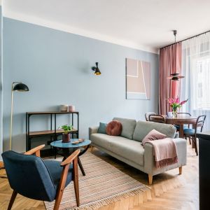 Oświetlenie i regały w salonie wprowadzają też nieco loftowy klimat. Projekt i stylizacja wnętrza: Ola Dąbrówka, pracownia Good Vibes Interiors. Zdjęcia: Marcin Mularczyk