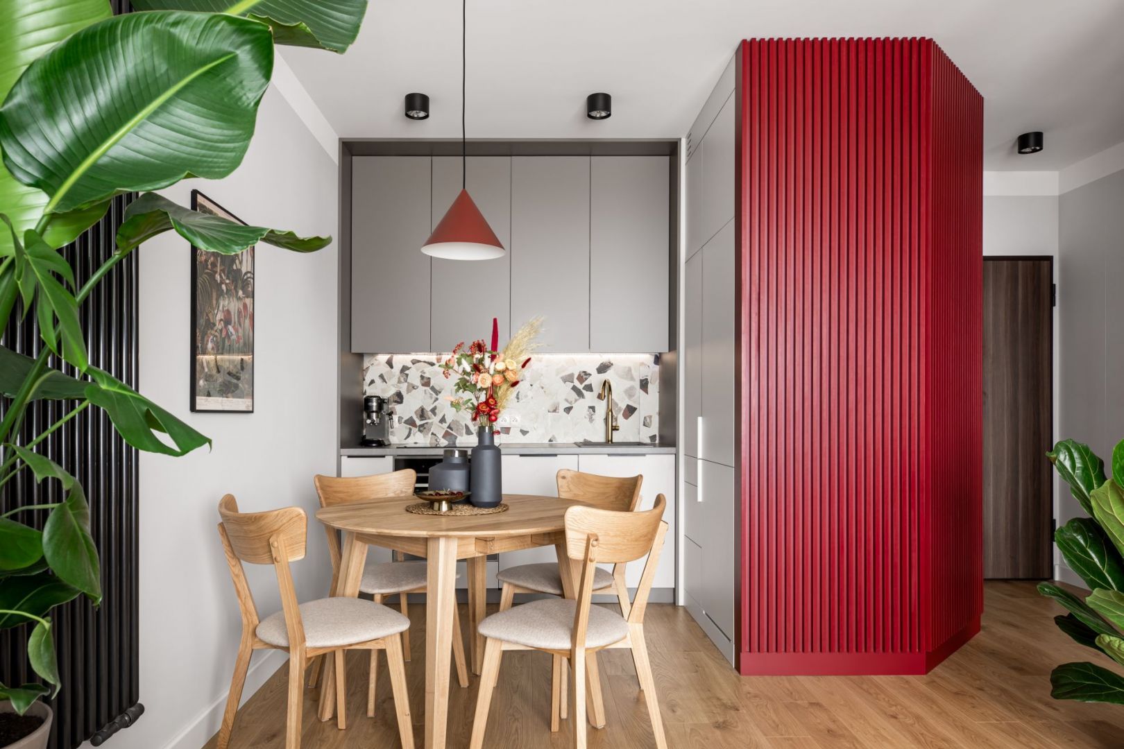 Kolor w kuchni. Elementy w czerwonym kolorze ożywiają niedużą kuchnię połączoną z jadalnią. Projekt: Maria Nielubszyc, pracownia PURA design. Fot. Jakub Nanowski