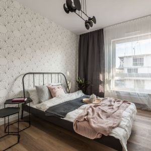 Ściana za łóżkiem w sypialni wykończona jest jasną tapeta o delikatnym wzorze. Projekt: Ewelina Matyjasik-Lewandowska. Fot. Tomasz Kazaniecki