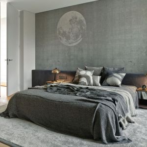 Ściana za łóżkiem w sypialni wykończona jest szarą tapetą. Projekt: Katarzyna Kraszewska Architektura Wnętrz. Fot. Tom Kurek
