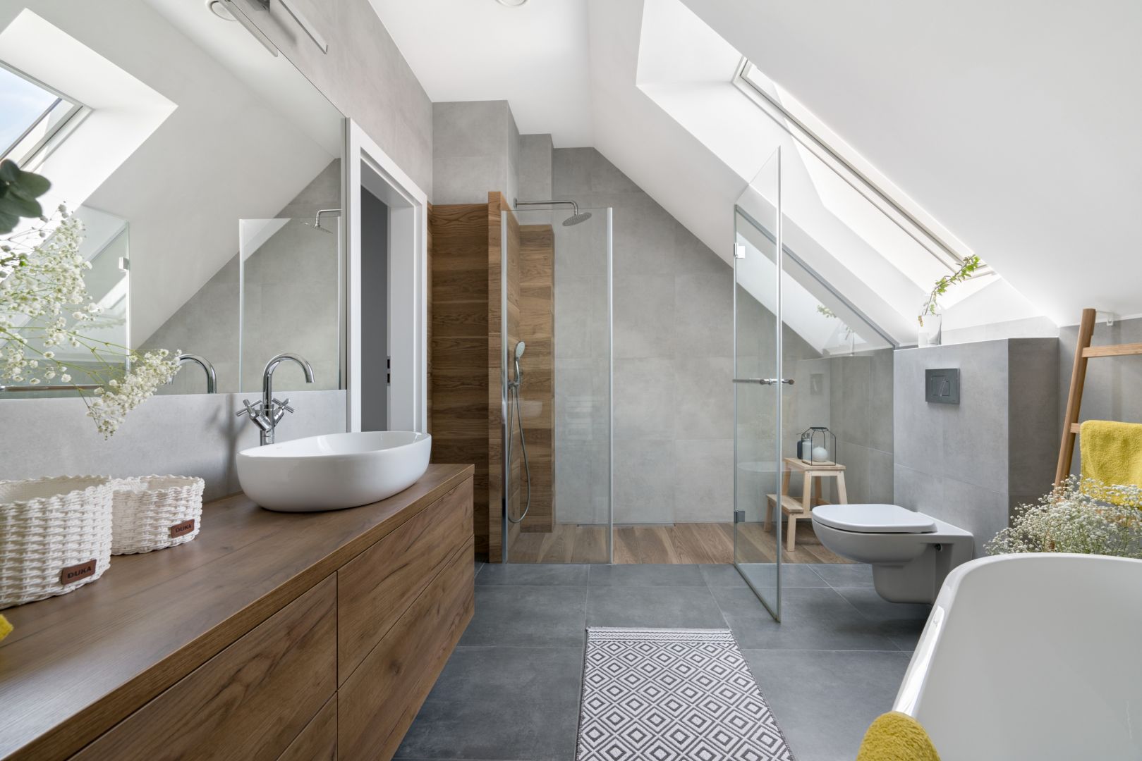 W łazience sprawdzają się szare płytki i te w kolorze drewna - najmniej widać na nich kurz i kamień. Projekt: MM Architekci. Fot. Jeremiasz Nowak
