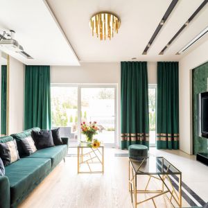 Zielone, welurowe zasłony wtapiają się w stylistykę salonu. Projekt Trędowska Design fot Michał Bachulski