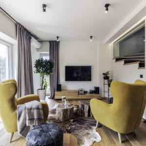 Ściana za telewizorem w salonie wykończona jest białą farbą. Ściana idealnie pasuje do drewna i do koloru. Projekt: Dominika Jurczak, DK architektura wnętrz. Fot. Krzysztof Czapor