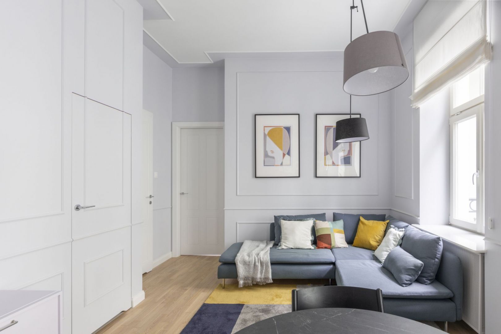 Mały salon w bloku ze sztukaterią na ścianie oraz z dębową podłogą. Projekt: Decoroom. Fot. Pion Poziom